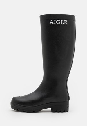 Black rubber rain boot with a smooth texture, high shaft, and a sturdy, ridged sole. Features a white AIGLE logo on the front.
