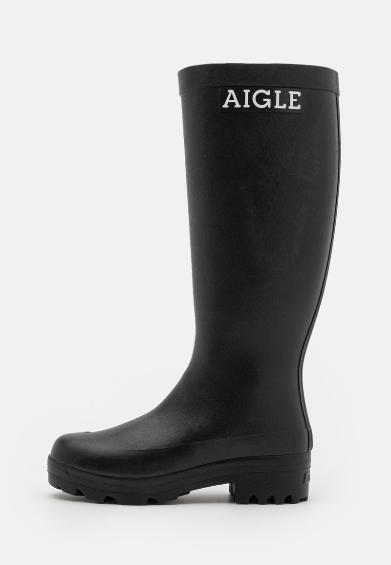 Botte de pluie noire en caoutchouc avec une texture lisse, une tige haute et une semelle robuste à nervures. Présente un logo AIGLE blanc à l'avant.
