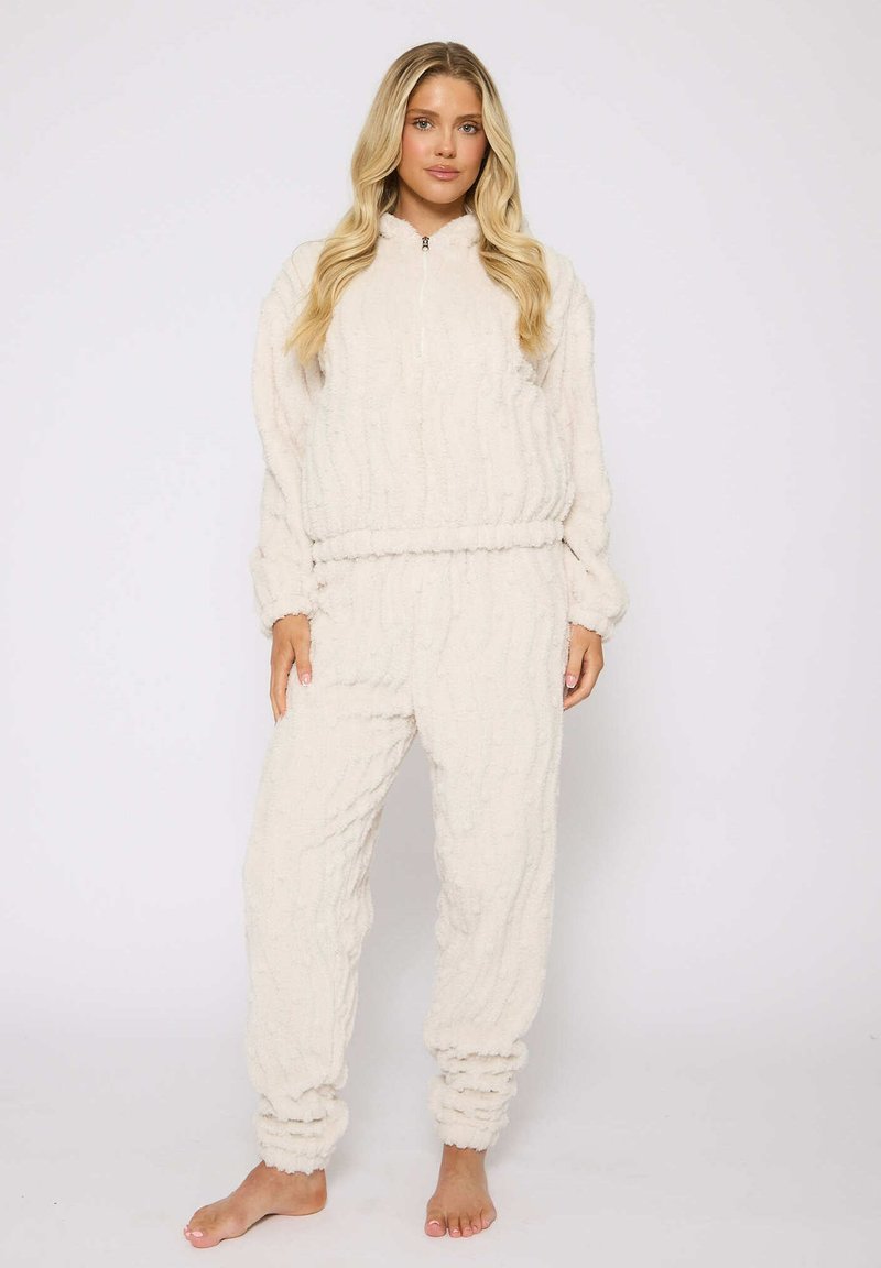 Set di abbigliamento loungewear in pile crema con top con zip e polsini elasticizzati, caratterizzato da motivi ondulati testurizzati e pantaloni dalla vestibilità comoda con caviglie arricciate.
