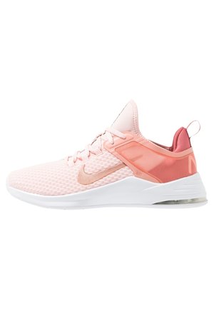 Lyserød Nike løbesko med hvid sål, net øverste, orange accenter og en synlig luft pude i hælen.