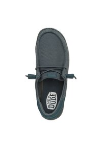 Zapato gris de malla tipo slip-on con punta redondeada, cordones elásticos y suela de goma texturizada. Logo visible en la plantilla. Sin patrones o acentos prominentes.