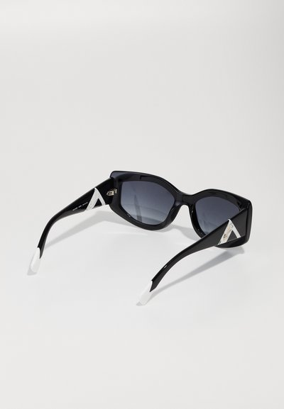 Black sunglasses with square lenses and gray tint. The arms feature a white accent and a geometric pattern near the hinges.