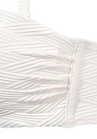 Reggiseno bianco in tessuto con design testurizzato e plissettato, caratterizzato da motivi a zigzag e spalline sottili. La cucitura è visibile lungo i bordi.