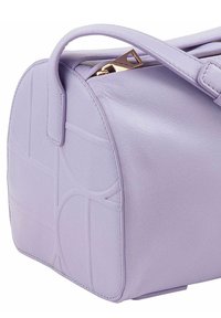 Borsa a mano in pelle lavanda con una texture liscia, forma arrotondata, manico superiore e hardware in tonalità oro. Motivo decorativo impresso sul lato.
