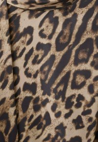 Tessuto con stampa leopardata in tonalità beige e marrone, con macchie nere irregolari e una texture liscia. Design dettagliato con motivi naturali.