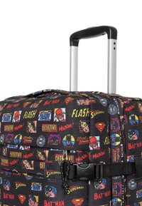 Rolling suitcase with superhero comic book print, black fabric, silver handle, black accents, zippered pockets, and durable strap buckle.