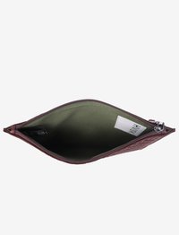 Bruine gewatteerde pouch met groene stofvoering, open rits en een witte rechthoekige label binnenin.