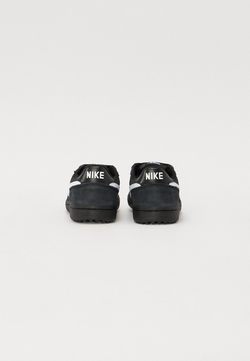 Czarne zamszowe sneakersy z białymi akcentami i brandingiem "NIKE" na pięcie. Posiadają teksturowaną gumową podeszwę zapewniającą przyczepność i trwałość.
