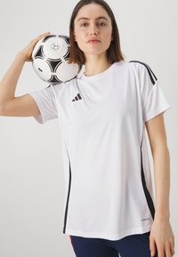 Witte Adidas sport T-shirt met zwarte accenten, korte mouwen en een ronde halslijn. De gestructureerde stof is lichtgewicht en ademend.