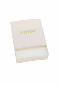 Caja color crema con una tapa curva, que presenta la palabra "amor" en texto dorado. El interior es blanco con una textura suave.