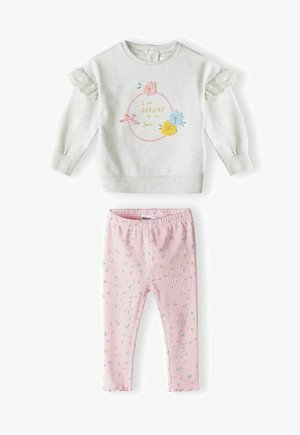 Szara bluza z koronkowym wykończeniem na rękawach, w kwiatowy nadruk i złoty tekst. Różowe leginsy ribbed z małymi wielokolorowymi wzorami kwiatowymi.