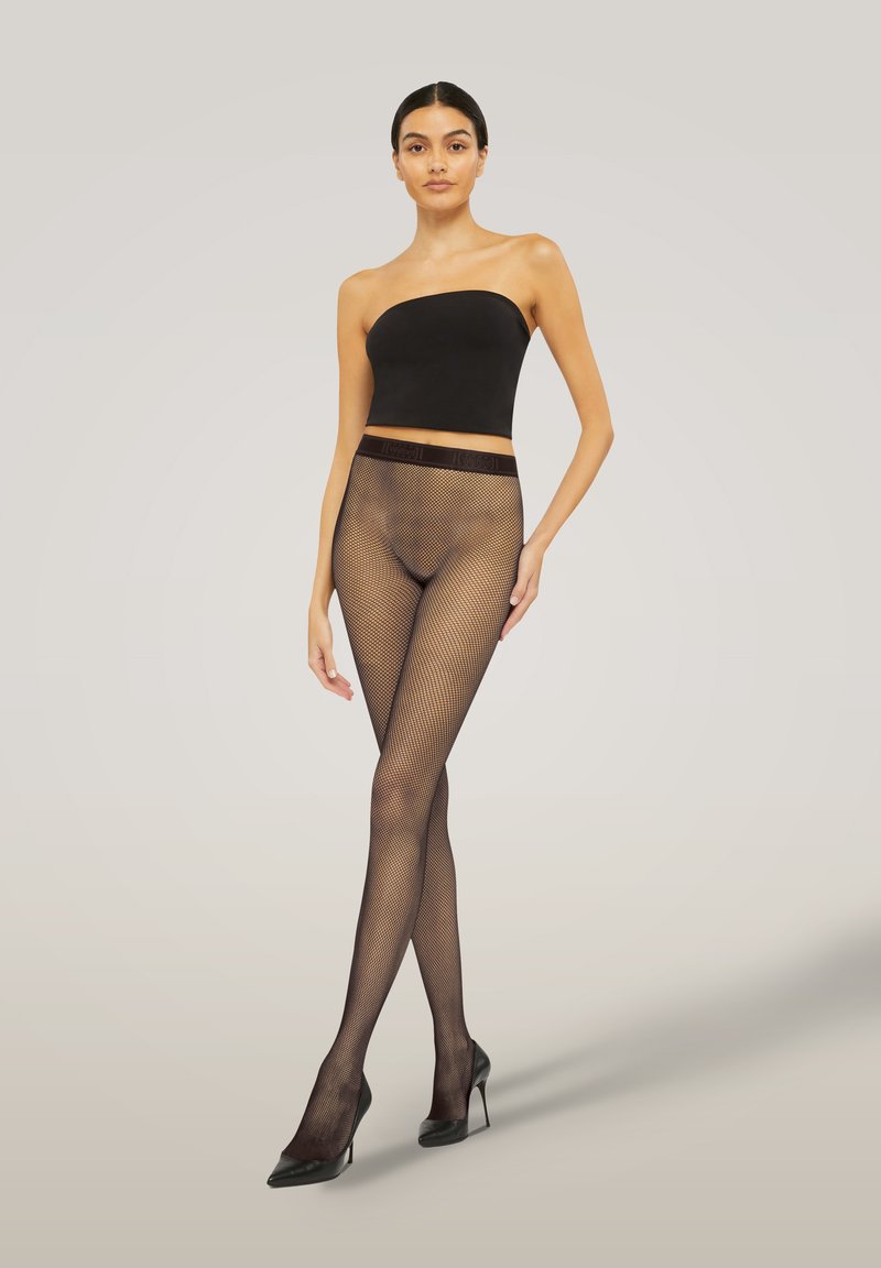 Collant in rete nera con un design testurizzato, vita alta, abbinati a un top senza spalline nero e scarpe con tacco alto nere.