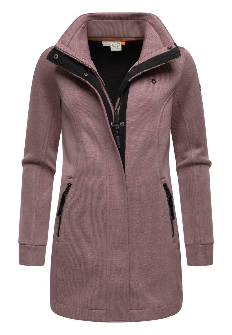 Lång rosa kappa med hög krage, svart dragkedja och två fickor med dragkedja. Tillverkad av textil med struktur och en figurnära design.