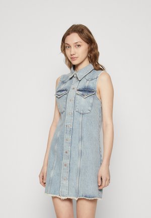 Denim kleita ar apkakli, bez piedurknēm, ar priekšējo pogu aizdari un divām krūšu kabatām. Gaiši zila krāsa ar saplēstu apakšmalu.