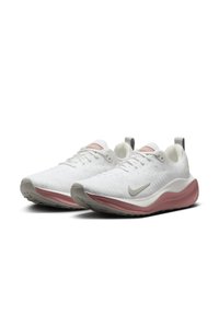 Baskets de sport blanches avec un dessus en tricot texturé, semelle intermédiaire rose et accents gris. Présentent des lacets ronds et une languette au talon.
