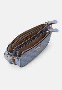 Sac à main bleu clair à double compartiment avec fermetures éclair dorées et chaîne, intérieur beige, et plaque logo à l'avant.