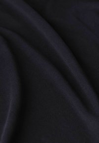 Tissu noir avec une texture lisse et légèrement extensible, présentant un léger brillant et des plis délicats, adapté à divers vêtements.