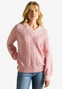 Roosa kudumipesu, millel on põimikmustrit, V-kaelus ja soonikusäär. Varrukatel on triibulised aktsendid mansettides.