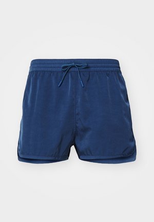 Marineblaue Badehosen mit elastischem Bund und Kordelzug. Glatte Textur mit seitlichen Schlitzen. Minimalistisches Design, keine zusätzlichen Muster oder Akzente.