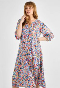Blumenkleid mit einem lebhaften Muster aus roten, blauen und gelben Blumen, mit Dreiviertelärmeln und einem taillierten Knoten.