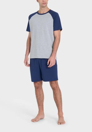 T-shirt grigia con maniche raglan blu navy abbinata a shorts blu navy. Tessuto in cotone, vestibilità standard, senza motivi o accenti visibili.