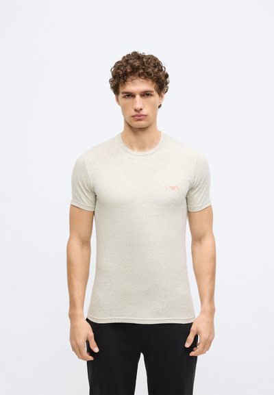 Gaiši pelēka kokvilnas vīriešu T-krekls ar īsām piedurknēm un apaļu izgriezumu, ar mazu rozā logotipu kreisajā krūšu daļā.