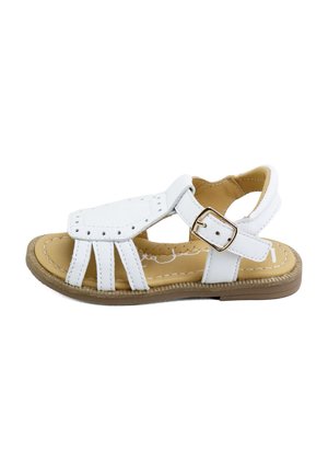 SANDALIA infantil blanca con dedos abiertos, correa ajustable con hebilla y suela acolchada marrón claro con costuras blancas.