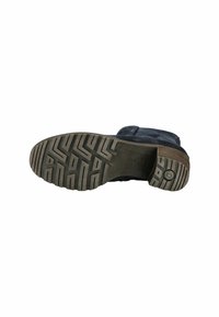 Botte en daim noir avec une semelle en caoutchouc texturé, présentant un motif de semelle à zigzag et un détail de logo rond sur la semelle extérieure.