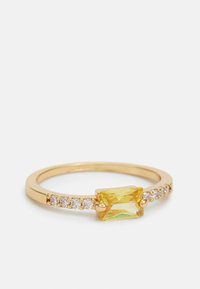 Anello d'oro con un rettangolo di pietra gialla al centro, affiancato da piccole pietre trasparenti rotonde lungo la fascia.