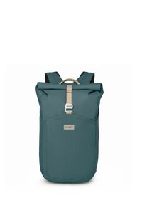 Mochila de color verde azulado con una correa beige y correas ajustables para los hombros. Cuenta con un bolsillo delantero y la marca Osprey en la parte frontal.
