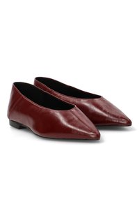 Bailarinas de cuero burdeos con punta afilada, tacón bajo y textura suave. El interior es negro, mostrando un diseño elegante y minimalista.
