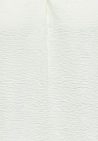 Surface blanche texturée avec de légers plis horizontaux et verticaux, ressemblant à du tissu ou du papier froissé.