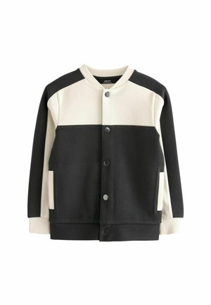 Veste varsity noire et crème avec fermeture par boutons, poignets côtelés et poches latérales. Présente un design en blocs de couleurs avec des panneaux contrastants.
