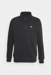 Black sweatshirt with a high collar and quarter zip. Features ribbed cuffs and hem, with a small logo on the left chest. Soft texture.