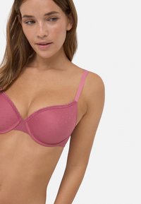 Sujetador rosa con aros, con puntos texturizados, adornado con encaje en el borde superior y tirantes finos ajustables. Diseñado para un ajuste que brinda soporte.