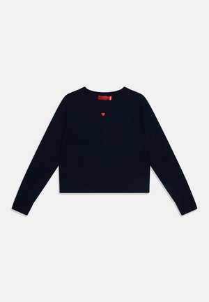 Mørkeblå kort genser laget av strikket stoff, med lange raglanermer og en liten rød hjertebrodering på brystet.