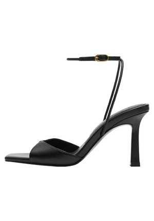 Sandale à talon haut noire avec fine bride autour de la cheville et boucle dorée, bout ouvert, et design à bout carré sur fond blanc.