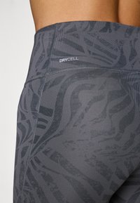 Hallid hallid spordileggingsid, millel on tekstuuriga muster ja "DRYCELL" logo. Valmistatud venivast kangast, millel on sile pind.