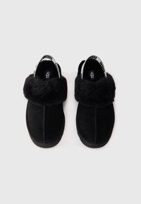 Sorte slip-on sko med semsket ytre, myk svart pelsfôr og en kontrasterende merket stropp ved hælen.