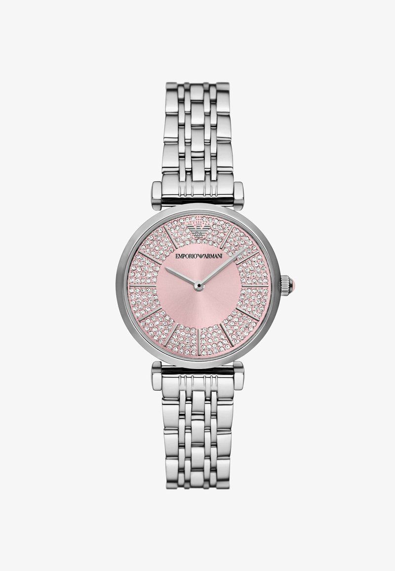 Stříbrné nerezové ocelové hodinky s kulatým růžovým ciferníkem, zdobené krystaly v vzoru slunečních paprsků, a náramkovým páskem z článků.