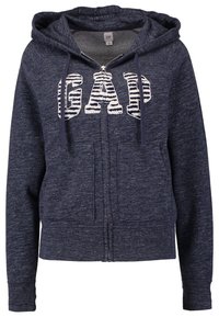 Sweat à capuche zippé bleu marine avec poches avant et capuche, présentant de grandes lettres texturées « GAP » en blanc et des rayures bleu marine sur la poitrine.