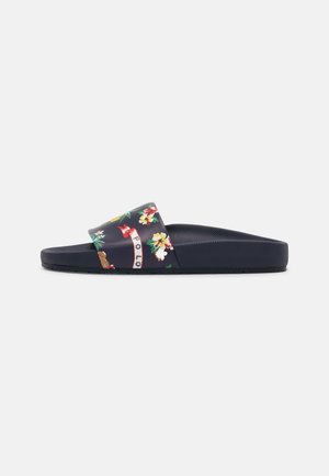 Sandale à enfiler bleu marine avec semelle moulée et bride imprimée de fleurs portant le mot « POLO » dans un style décontracté.