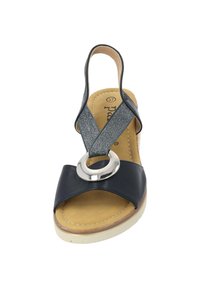 Marineblauwe sandaal met een brede band en zilveren ronde sluiting. Heeft een gestructureerde elastische band en een beige gewatteerde inlegzool.