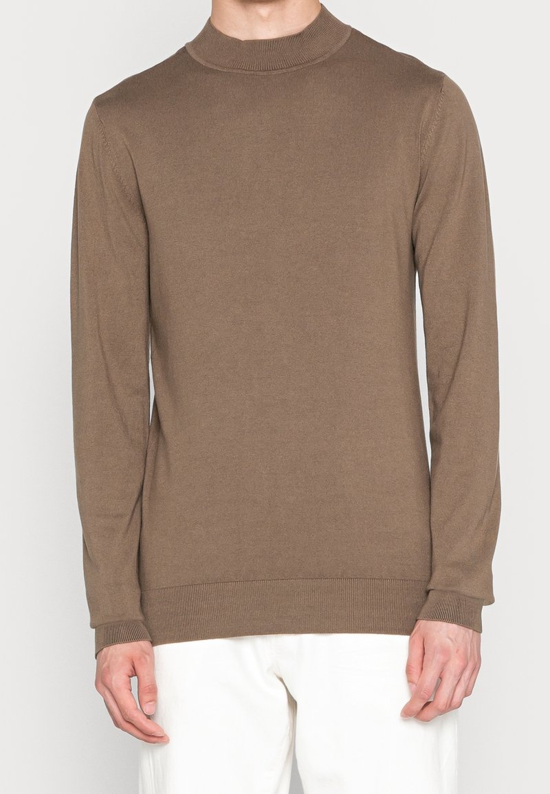 Brown, fitted long-sleeve sweater with a high neck and ribbed cuffs and hem, made from soft, lightweight material.