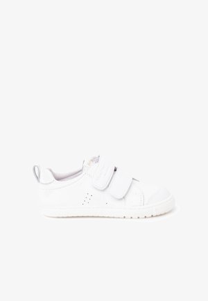 Hvid børnesneaker med to justerbare velcroremme, perforeret sidetegning og trækflig på hælen.
