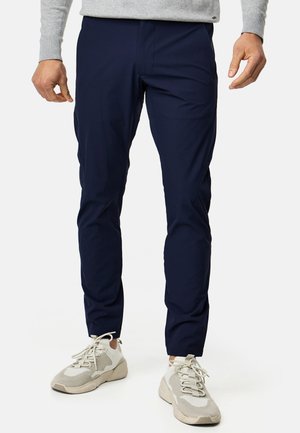 Navy blue lightweight pants with a tailored fit, featuring a smooth texture and subtle side pockets. Paired with off-white sneakers.