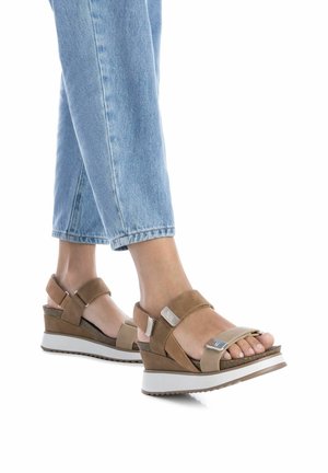 Sandali con zeppa, con cinturini in suede marrone e tan, dettagli in argento e una suola in gomma bianca. Presentano un plantare testurizzato.