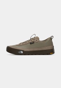 Light brown hiking shoe with a durable Cordura upper, rubber toe cap, and Vibram outsole. Features laces and a pull tab at the heel.