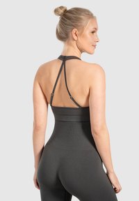Donkergrijze sportieve tanktop met een racerback ontwerp en verstelbare bandjes, voorzien van een ribbeltextuur en een getailleerde taille.