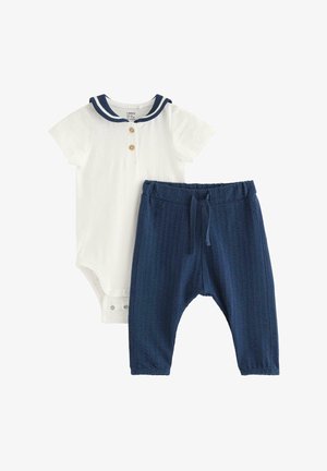 Hvid babyheldragt med korte ærmer, navy sømandshals og to knapper, kombineret med teksturerede navy blå elastiske bukser.
